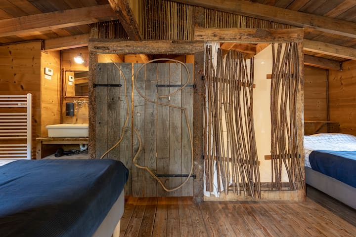 La cache de Félix – La chambre et la douche, avec sa cloison en branches